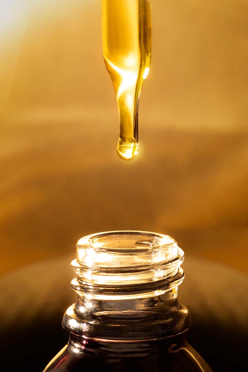 Root & Ritual Gallery – Macro Oil dropper with oil with golden light